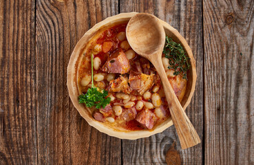 Smoked pork and beans stew on a rustic table