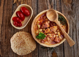 Smoked pork and beans stew on a rustic table