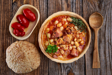 Smoked pork and beans stew on a rustic table