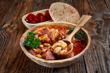 Smoked pork and beans stew on a rustic table