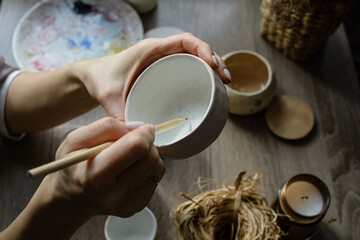 Hand-painting homemade ceramic dishes.