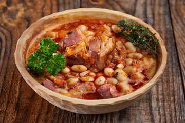 Smoked pork and beans stew on a rustic table