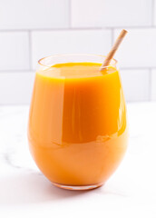 An Orange Smoothie on a Bright Kitchen Cabinet
