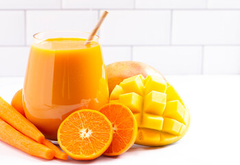Orange Carrot and Mango Smoothie on a Bright Kitchen Cabinet