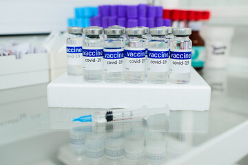 glass medical jars with the inscription covid-19 vaccine on the glass surface in the clinic.