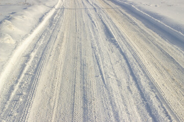 Snow covered icy road in forest in winter