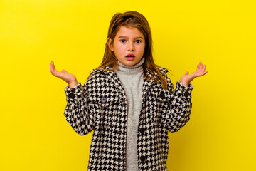 Little caucasian girl isolated on yellow background surprised and shocked.