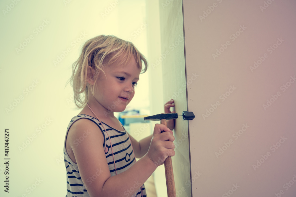 Wall mural cute blonde girl renovating her room building a closet.