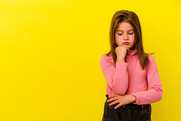 Little caucasian girl isolated on yellow background looking sideways with doubtful and skeptical...