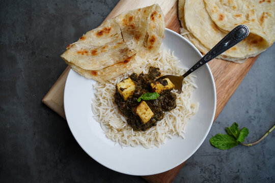 Palak Paneer or Saag Paneer-Indian cottage cheese with Spinach served with rice and roti, selective focus