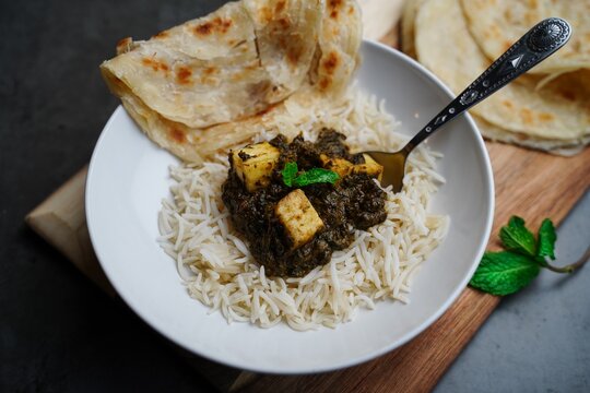 Palak Paneer or Saag Paneer-Indian cottage cheese with Spinach served with rice and roti, selective focus