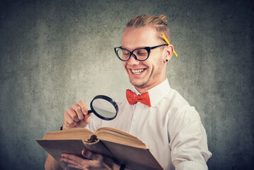 Fototapeta na wymiar Portrait of a nerdy man reading an old book
