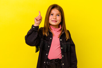 Little caucasian girl isolated on yellow background indicates with both fore fingers up showing a...