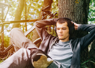 Lie in the park by a tree and enjoy listening to music, relax after a bike ride