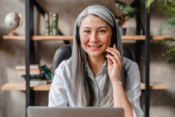 Smart nice-looking white mature woman hot line worker at work place in office