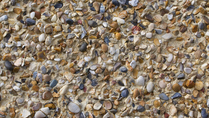 Full frame pebble dash background with multiple coloured embedded stones