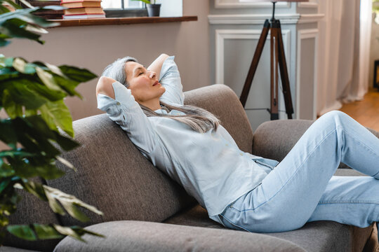 Mature grey-haired woman relaxing on the sofa in casual clothes