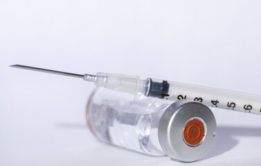 a vial containing clear fluid is shown with a syringe