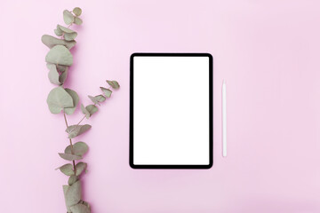Tablet with white screen on pink color background. Flatlay. With color pallet on the table