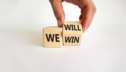 We will win symbol. Businessman turns cubes and changes words we will to we win. Beautiful white background, copy space. Business, motivational and we will win concept.