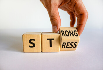 Strong stress symbol. Businessman turns wooden cubes with words 'strong stress'. Beautiful white background, copy space. Business and strong stress concept.