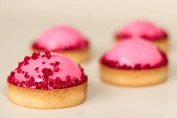 Mousse raspberry cakes in round shortcrust pastry tartlets covered with mirror glaze