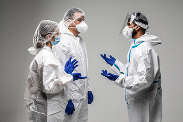 Three healthcare workers have informal meeting wearing in hazard isolated on white background
