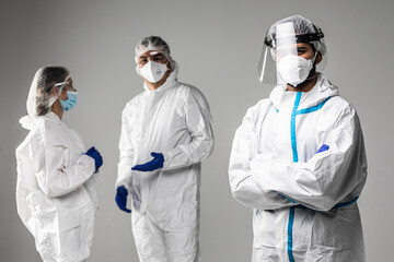 Male doctor standing in front of collegues that have informal meeting wearing in hazard on white background