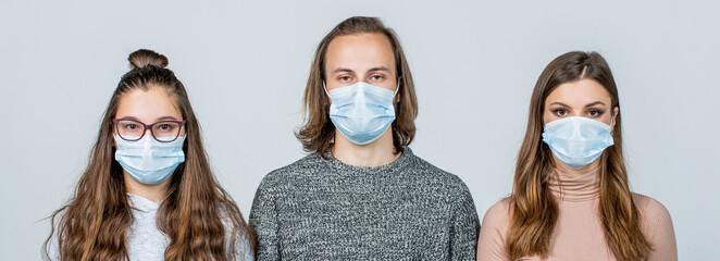 Group young people wearing face mask for preventing corona virus outbreak. Health, quarantine and pandemic concept - group of people wearing protective medical masks for protection from virus