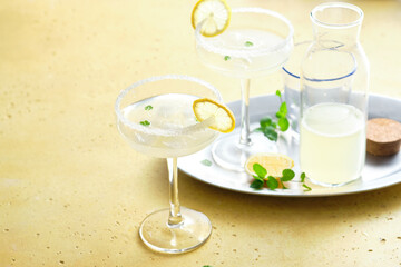 Classic lemonade with mint and lemon slices on yellow background