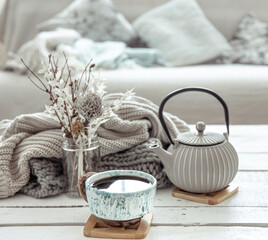 Cozy Scandinavian composition with teapot, ceramic cup of tea and decor details.