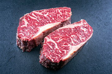 Rohes dry aged Wagyu Roastbeef Steak vom Rind angeboten als close-up auf einem schwarzen Board mit...