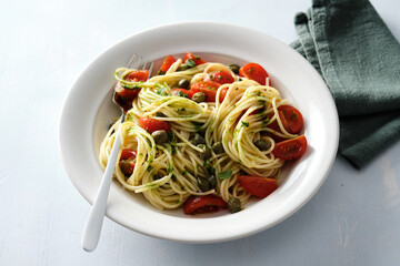 Pasta, spaghetti with tomato in white bowl on grey stone background. Top view.