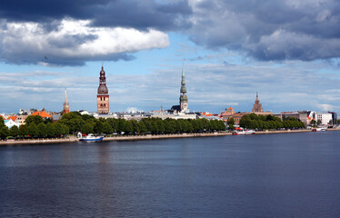 Obraz premium Nice view of the old town of Riga from the Daugava river. Beautiful cityscape with soft clouds