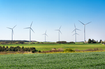The wind turbine, or wind energy converter group in Germany against the backdrop of a spring landscape.