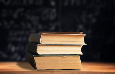 pencil on book on math chalkboard