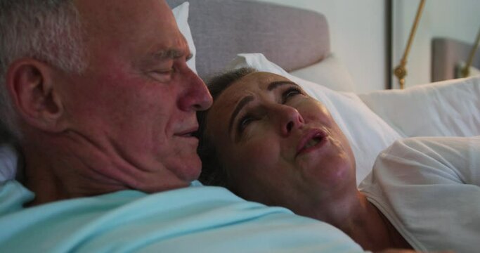 Close up of caucasian senior couple laughing together in bed at home
