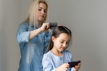 Mother treating daughter's hair against lice