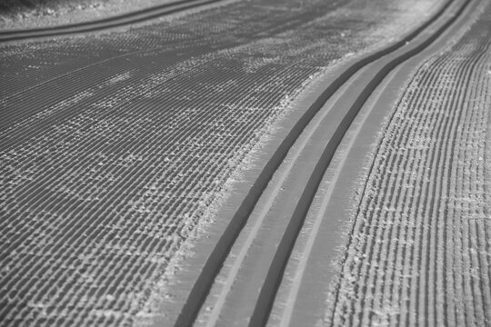 freshly groomed cross country nordic skiing tracks in fresh snow for classic skiing or skate skiing for winter winter activity sport leading lines and corrugated horizontal format room for type