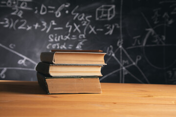 Books on table on blackboard background