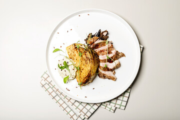 Top view duck breast with cabbage steak with cheese sauce. Delicious restaurant dish on a round plate on a checkered napkin