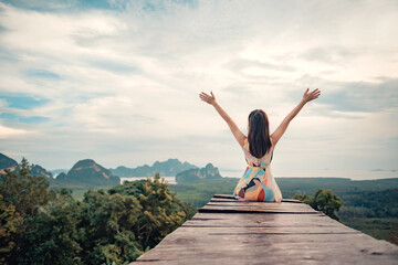 Freedom traveler woman relaxing with raised arms on the top of mountain at Samed nang chee Thailand, Enjoy travel concept.
