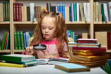 preschool girl reading book in library with patience, caucasian kid girl is concentrated on education, getting knowledge. child s brain development, learn to read, cognitive skills concept