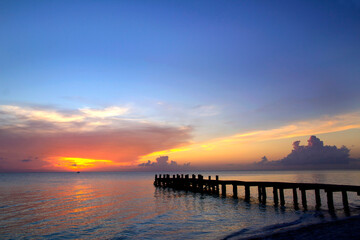 Fototapeta na wymiar Nice pier with amazing colorful sunset background at Caribbean Sea