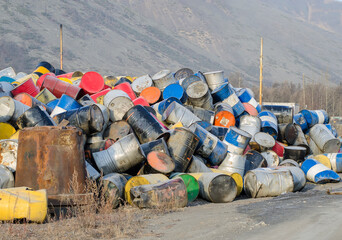 Dumping metal drums for fuel in a mountainous area.