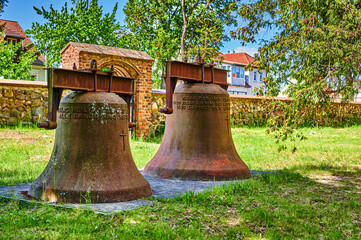 Old, rusty church bell on a meadow in the rural municipality of Rangsdorf in Germany.