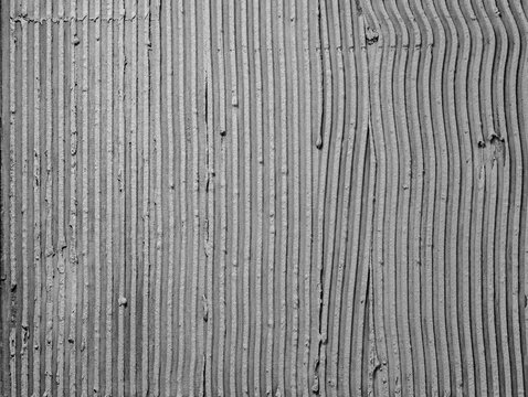 Texture applied tile adhesive on wall, ribbed concrete background close-up.