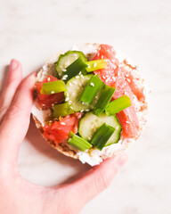 Simple open sandwiches on bread with salmon and cucumber, green, with hand. The concept of healthy eating.