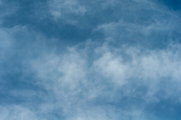 Reflections warm rays setting sun, swirls strong gust wind, outdoors. Bright blue sky, white translucent feathery clouds. Horizontal photography