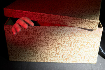 Man's hand coming out of the inside of a box